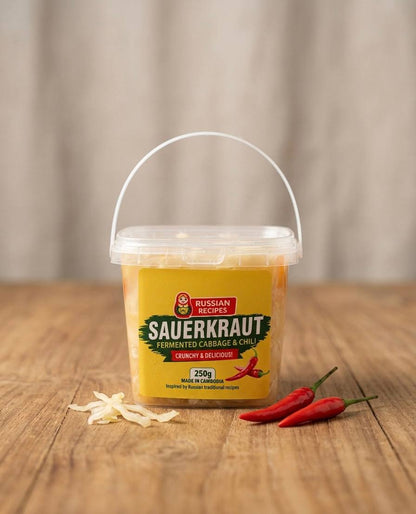 Container of Russian Recipes Sauerkraut with red peppers on a wooden surface