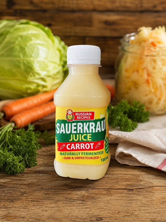 A bottle of Russian Recipes Sauerkraut Juice with carrot flavor, set on a rustic wooden table surrounded by fresh cabbage, carrots, parsley, and a glass jar of sauerkraut.